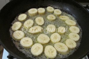 <p>Займёмся бананами: 200 г очищенных бананов нарезаем ломтиками толщиной 0,7-0,8 см. На сковороде подтапливаем 33 г сливочного масла и всыпаем 38 г сахара. Когда сахар начал плавиться, выкладываем бананы в один слой.</p>
