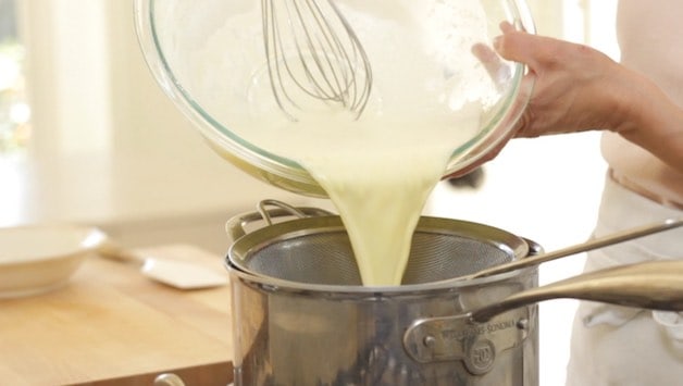 Pastry Cream Mixture Being Strained through a Fine Mesh Sieve into a pot