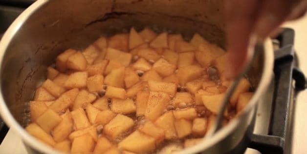 Apple chunks cooking in pot with cinnamon for a French Apple Tart Recipe