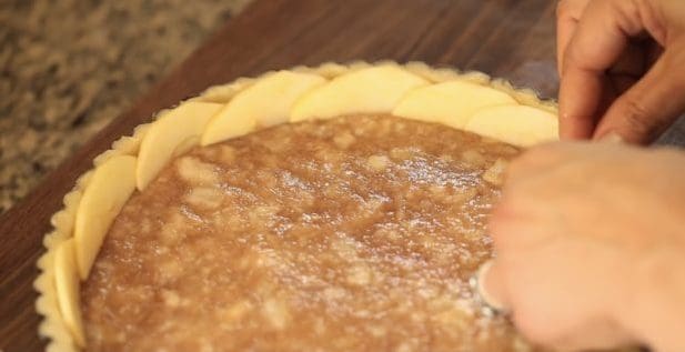 Adding apple slices to the top of a French Apple Tart
