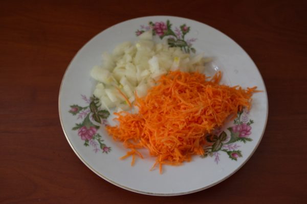 Рубленый репчатый лук и тёртая морковь на тарелке с цветочными узорами