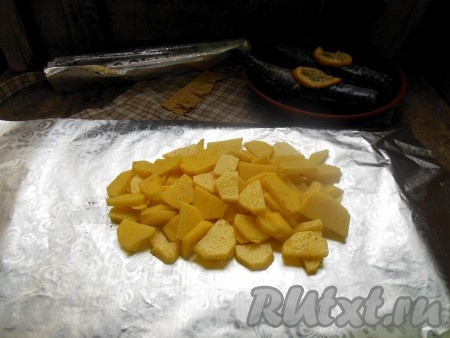 На лист фольги выложите половину подготовленного картофеля.
