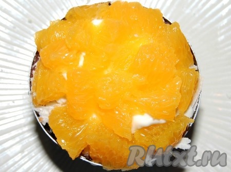Апельсины аккуратно отделить от белых пленок и использовать только желтую мякоть.  Нарезать мелкими сегментами и уложить поверх сыра.