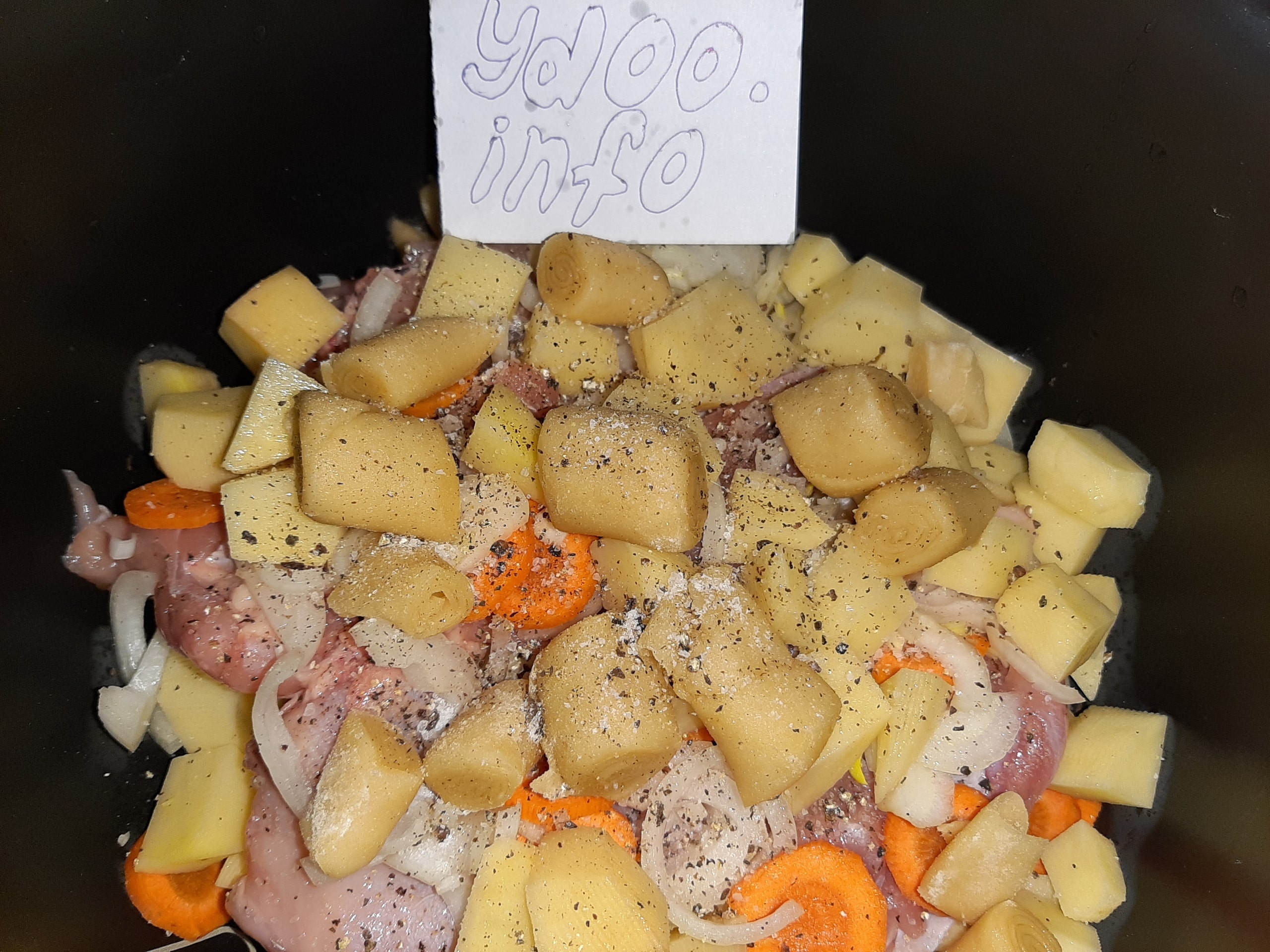 кубики картофеля, нарезанное мясо, морковь и лук с кусочками теста, присыпанные специями, в казане