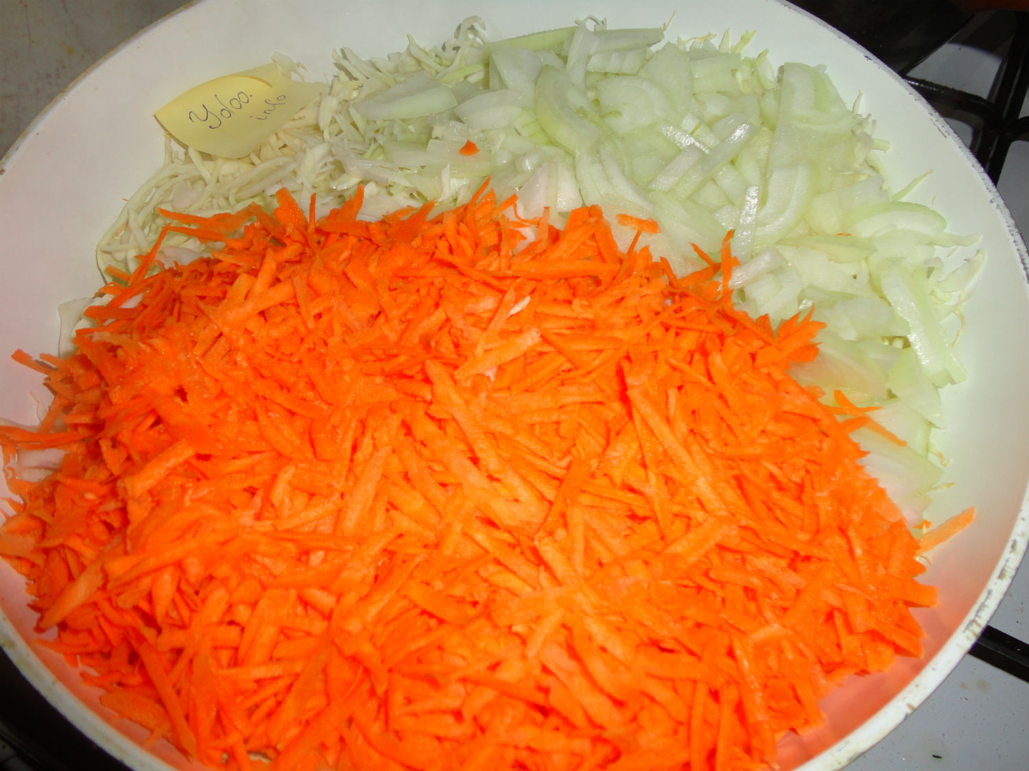 измельченные морковь и лук в сковороде с нашинкованной капустой